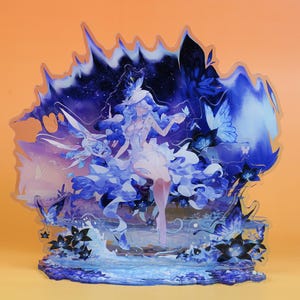 Puede incluir: Figura decorativa de acrílico con una ilustración de fantasía. La obra de arte representa a una mujer con un vestido fluido con detalles azules y blancos, rodeada de mariposas y elementos florales. La paleta de colores incluye tonos de azul, blanco y morado.