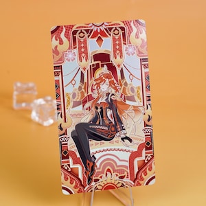 Puede incluir: Una tarjeta rectangular con una ilustraci&oacute;n estilizada de un personaje con cabello rojo y un atuendo negro. La tarjeta tiene un borde decorativo con tonos rojos, naranjas y dorados. El personaje est&aacute; sentado, y el fondo tiene patrones ornamentados.