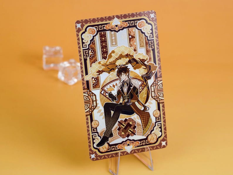 Puede incluir: Una tarjeta decorativa con un personaje de estilo anime con un atuendo marr&oacute;n y dorado, sobre un fondo detallado con patrones geom&eacute;tricos. La tarjeta se muestra en un soporte transparente sobre un fondo naranja.