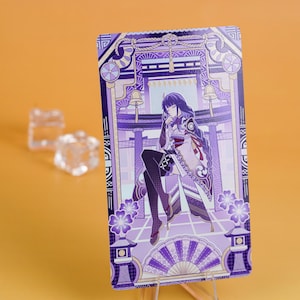 Puede incluir: Una tarjeta rectangular con una ilustraci&oacute;n detallada de un personaje con un kimono morado y blanco, sobre un fondo de una estructura japonesa tradicional. La tarjeta tiene una combinaci&oacute;n de colores morado y blanco con elementos florales y arquitect&oacute;nicos.