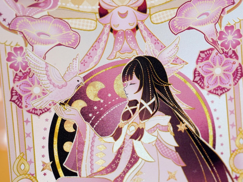 Puede incluir: Ilustraci&oacute;n detallada en tonos rosa y dorado, que representa a una mujer con largo cabello negro y una paloma. La obra de arte incorpora elementos florales y celestiales. La mujer tiene los ojos cerrados y la paloma est&aacute; posada en su mano. El dise&ntilde;o tiene acentos dorados.