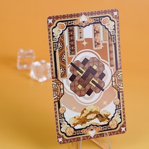 Puede incluir: Una tarjeta decorativa con un dise&ntilde;o marr&oacute;n y beige, con patrones geom&eacute;tricos y motivos de nubes. La tarjeta tiene forma rectangular y se muestra sobre un soporte transparente sobre un fondo naranja.