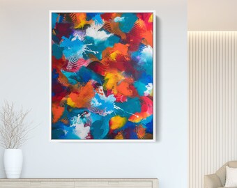 May include: Abstract painting with a white frame. The painting features a mix of blue, red, orange, and yellow paint in a swirling pattern.