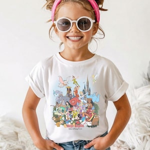 May include: A white t-shirt featuring a colorful graphic of various Disney characters, including Mickey Mouse, Dumbo, and Peter Pan. The shirt has rolled-up sleeves and is worn by a young person. The text "Magic Kingdom Walt Disney World" is visible.