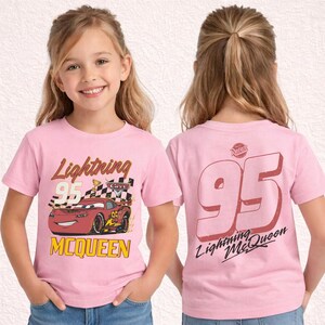May include: Pink Lightning McQueen t-shirt featuring a cartoon race car with the number 95 and the name McQueen. The back of the shirt displays a large number 95 and the words "Lightning McQueen".