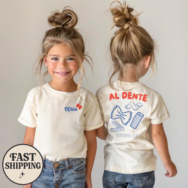 May include: Two children wearing cream-colored t-shirts with blue jeans. The front of the shirt has the name "Olivia" and a butterfly graphic. The back of the shirt has the words "AL DENTE" and pasta illustrations, with "PASTA LOVERS CLUB" below.