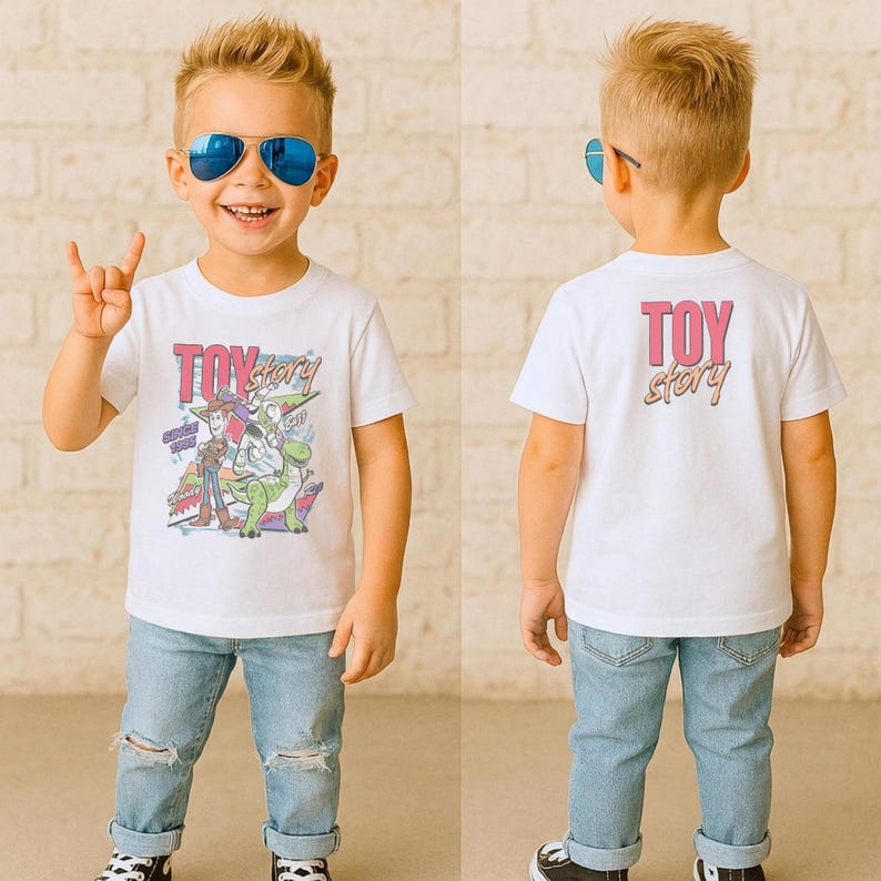 May include: A white t-shirt featuring the text "TOY STORY" in pink and a graphic of characters from the movie. The shirt is worn by a young child with blue sunglasses and ripped blue jeans.