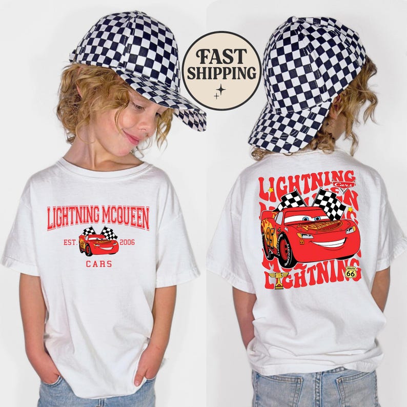 Puede incluir: Camiseta blanca con gr&aacute;ficos de Lightning McQueen de la pel&iacute;cula Cars. La parte delantera muestra "Lightning McQueen" y un gr&aacute;fico del coche. La parte trasera presenta un gr&aacute;fico m&aacute;s grande del coche con el texto "Lightning" y "Cars". Tambi&eacute;n se ve una gorra a cuadros.