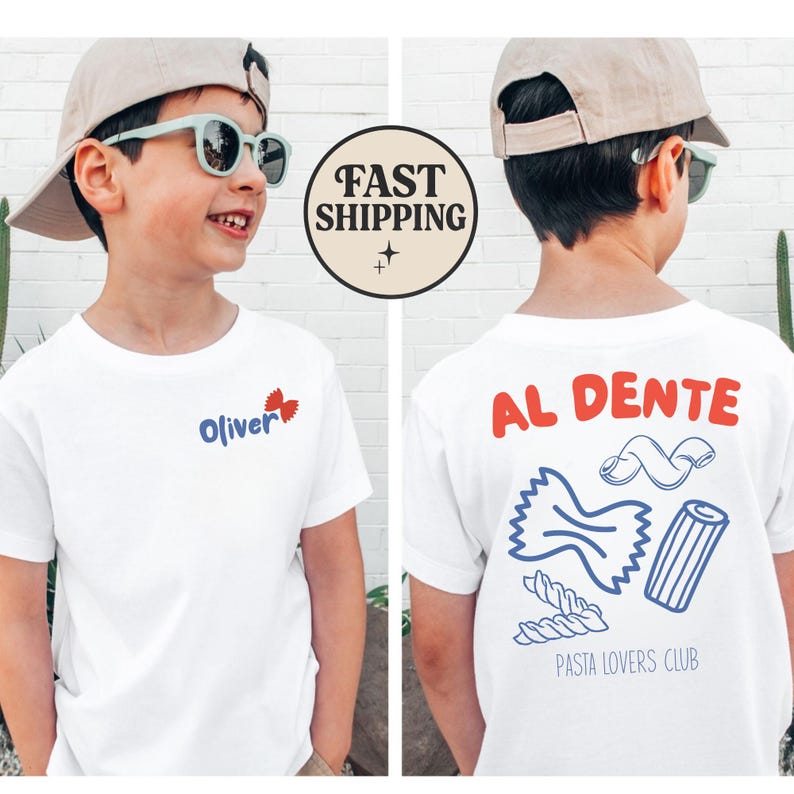 May include: White t-shirt with the name "Oliver" and a butterfly graphic on the front. The back of the shirt features the words "AL DENTE" and pasta illustrations, with "PASTA LOVERS CLUB" below. The shirt is worn by a child.