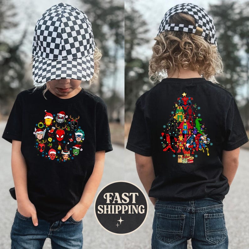 Może przedstawiać: Czarny t-shirt z świątecznym wzorem z postaciami Marvela w czapkach Świętego Mikołaja i lampkami choinkowymi. Tył koszulki przedstawia choinkę z postaci Marvela. Dziecko ma na sobie czarno-białą czapkę w szachownicę.