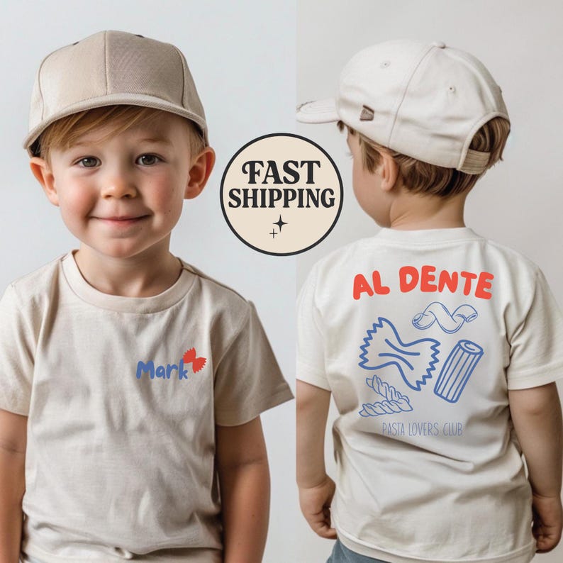 May include: A beige t-shirt with the name "Mark" and a red bow tie design. The back of the shirt features the words "AL DENTE" in red, pasta illustrations, and "PASTA LOVERS CLUB" in blue. The child is wearing a beige baseball cap.