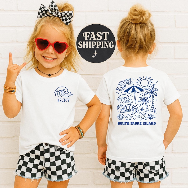 Op de afbeelding: Witte T-shirts met blauwe afbeeldingen. E&eacute;n shirt heeft een golfontwerp met de naam "BECKY", de andere heeft een strandsc&egrave;ne met de tekst "SOUTH PADRE ISLAND". De shirts worden gecombineerd met zwart-wit geruite shorts.