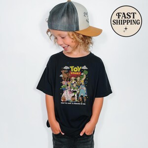 Puede incluir: Una camiseta negra con un gr&aacute;fico colorido de personajes de la pel&iacute;cula "Toy Story". La camiseta tiene las palabras "Toy Story" y "You've Got a Friend in Me" impresas. El ni&ntilde;o lleva una gorra de camionero.