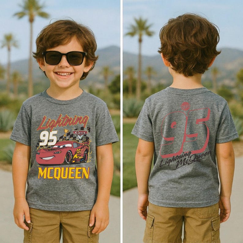 May include: A gray Lightning McQueen t-shirt featuring the number 95 and the character's image. The front of the shirt has the words "Lightning McQueen" and "95" in red and yellow. The back of the shirt has the number 95 and "Lightning McQueen" in red.