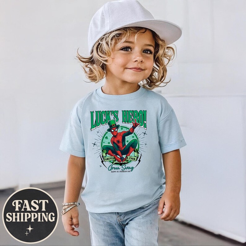 Puede incluir: Camiseta azul claro con un dise&ntilde;o de Spider-Man con un sombrero de duende verde. El texto en la camiseta dice "Luck's Hero!" y "Forever & Ever Green Swag Happy St. Patrick's Day."