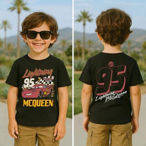 May include: Black t-shirt featuring Lightning McQueen from the Cars movie. The front graphic shows the car with the text "Lightning 95 McQueen". The back of the shirt displays "95 Lightning McQueen" in a pink and white design.