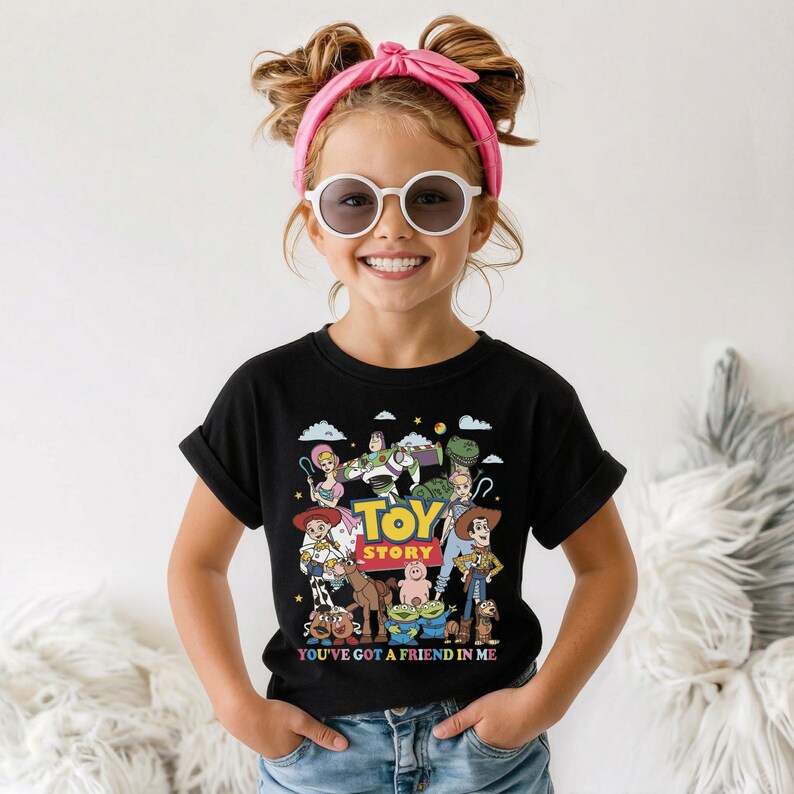 Op de afbeelding: Zwart T-shirt met een kleurrijke afbeelding van personages uit de film "Toy Story". Het ontwerp bevat de woorden "Toy Story" in geel en blauw, en de zin "You've Got a Friend in Me" onder de personages.