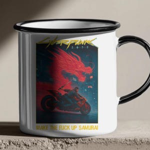 Puede incluir: Taza de esmalte blanco con borde y asa negros. La taza presenta un gr&aacute;fico vibrante de Cyberpunk 2077, que muestra un drag&oacute;n rojo, una persona en una motocicleta y el texto "WAKE THE FUCK UP SAMURAI".