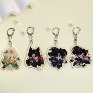 Puede incluir: Cuatro llaveros acrílicos con herrajes plateados. Cada llavero presenta un diseño de personaje de estilo anime diferente. Los personajes tienen varias combinaciones de colores, incluyendo verde, rojo y negro, con ilustraciones detalladas. Los llaveros están sobre un fondo amarillo claro.