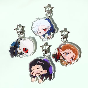 Puede incluir: Cuatro llaveros acrílicos con personajes de dibujos animados. Cada llavero tiene un diseño de personaje diferente, con diferentes colores de pelo y atuendos. Cada llavero tiene un cierre plateado en forma de estrella.