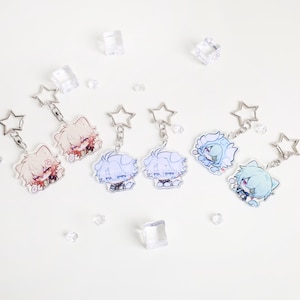 May include: Collection of anime-style character keychains. Each keychain features a colorful illustration of a character with unique hair and clothing. The keychains have star-shaped metal attachments and are on a white background.