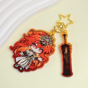 May include: A clear acrylic keychain with a cartoon character with red hair and a white outfit, and a sword-shaped charm. The keychain has a gold star-shaped clasp and a gold ring. The character has red eyes and a silver headpiece.