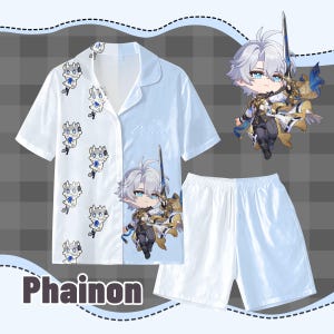 Puede incluir: Un conjunto de pijama blanco con una camisa de manga corta con botones y pantalones cortos a juego. La camisa tiene un diseño dividido con un estampado de personaje de dibujos animados en un lado y un patrón repetitivo en el otro. La palabra "Phainon" está impresa en la parte inferior.