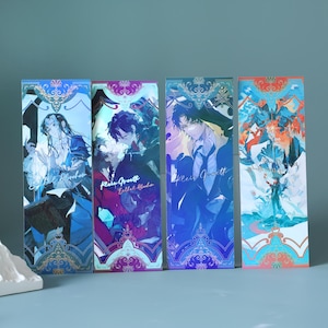 Puede incluir: Cuatro marcapáginas rectangulares con ilustraciones de estilo anime. Cada marcapáginas presenta un personaje diferente en tonos de azul, morado y naranja. Los marcapáginas tienen bordes decorativos e incluyen texto. El tema general es la fantasía o el manga.