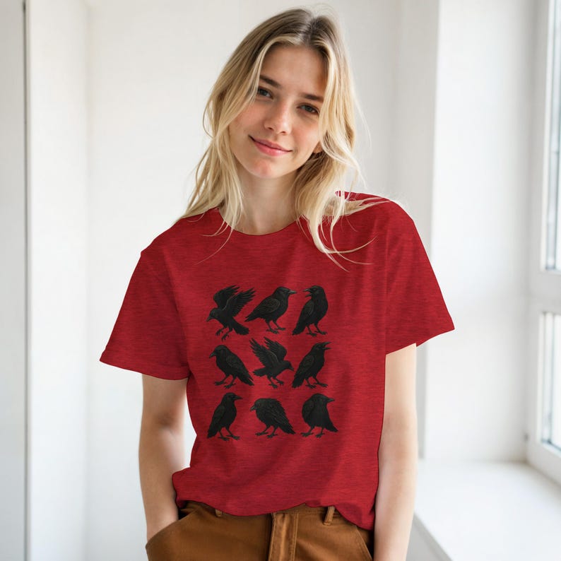 May include: Red t-shirt with a black crow design. The graphic features nine black crows in different poses. The shirt is made of a soft material and has a classic crew neck.