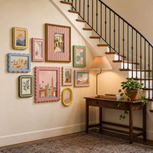 Puede incluir: Una pared de galería con diez marcos de fotos rectangulares y ovalados con bordes ondulados en varios colores, incluyendo rosa, azul, verde y amarillo, junto a una mesa consola de madera con una lámpara plisada y una planta en maceta.