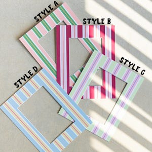 Op de afbeelding: Vier kleurrijke passe-partouts met strepen in verschillende stijlen. Stijl A heeft roze, groene en witte strepen. Stijl B heeft rode en witte strepen. Stijl C heeft groene, paarse en witte strepen. Stijl D heeft blauwe, gele en rode strepen.