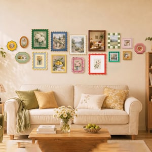 Può includere: Una parete galleria con quindici cornici decorative assortite di vari colori e forme, inclusi bordi smerlati, che espongono diverse stampe artistiche sopra un divano beige con cuscini verdi, gialli e color crema.