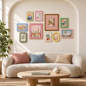 Könnte beinhalten: Eine Galeriewand mit zehn gerahmten Kunstdrucken in verschiedenen Formen und Farben, darunter gewellte und perlenbesetzte Rahmen, angeordnet über einem geschwungenen cremefarbenen Sofa mit drei Zierkissen und einem runden Couchtisch aus Holz.