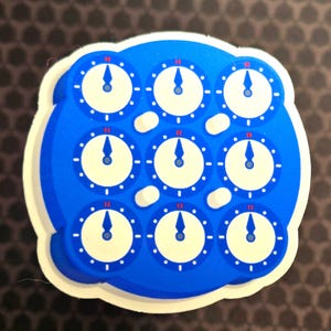 May include: A blue and white sticker featuring nine clock faces arranged in a grid. Each clock has a white face, blue hands, and a blue border. The sticker has a white border.