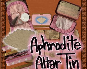 May include: An Aphrodite Altar Tin with pink and gold accents. The tin contains a variety of items, including a seashell, candles, and small containers. The text "Aphrodite Altar Tin" is prominently displayed.