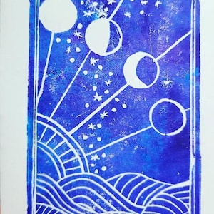 May include: A blue and white linocut print showing the phases of the moon, stars, and stylized waves. The print has a rectangular border and white lines on a dark blue background. The design includes a sun and moon phases.