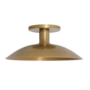 May include: A gold-colored, semi-flush mount ceiling light fixture. The light has a circular base, a cylindrical stem, and a wide, shallow, bowl-shaped shade. The fixture is made of metal and has a smooth, reflective surface.