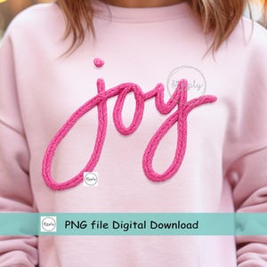 以下が含まれることがあります： 明るいピンク色のスウェットシャツ。鮮やかなピンク色のテクスチャード加工されたフォントで「joy」の文字が書かれています。テキストは筆記体です。「PNG file Digital Download」の文字が画像の下部にあります。