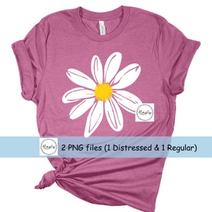 May include: A pink t-shirt with a white daisy graphic. The daisy has a yellow center. The text "2 PNG files (1 Distressed & 1 Regular)" is at the bottom of the image.