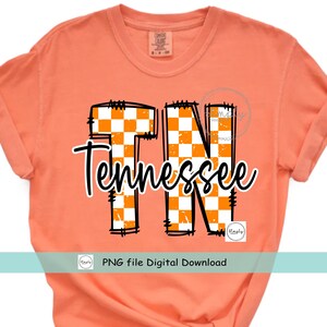 May include: Peach-colored t-shirt with the word "Tennessee" in a black script font. The letters "TN" are filled with an orange and white checkered pattern. The shirt also includes the text "PNG file Digital Download".