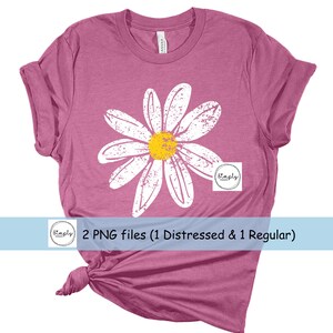May include: A pink t-shirt with a distressed white daisy graphic. The daisy has a yellow center. The text "Simply" is in a circle on the shirt.