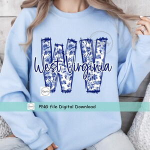 May include: Pale blue sweatshirt with the words "West Virginia" in a cursive font. The letters "WV" are filled with a blue floral design. A small logo and the text "PNG file Digital Download" are also visible.