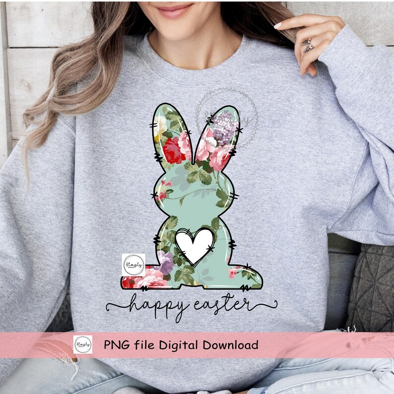 May include: A gray sweatshirt with a floral bunny design and the text "happy easter". The bunny is outlined in black and has a white heart in the center. The text "PNG file Digital Download" is at the bottom of the image.