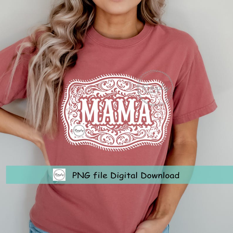 May include: A dusty rose-colored t-shirt featuring a white decorative graphic with the word "MAMA" in bold letters. The graphic is framed by an ornate, scroll-like design. The shirt also has the text "PNG file Digital Download".