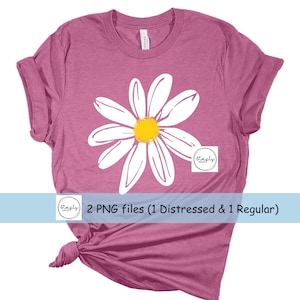May include: A pink t-shirt with a white daisy graphic. The daisy has a yellow center. The text "2 PNG files (1 Distressed & 1 Regular)" is at the bottom of the image.