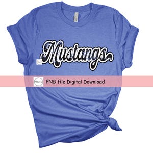 May include: A blue t-shirt with the word "Mustangs" in black and white lettering. The lettering is in a glittery font.