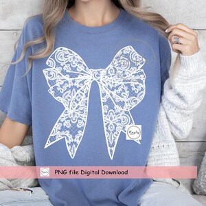 Puede incluir: Un dise&ntilde;o de lazo de encaje blanco sobre una camiseta azul. Descarga digital de archivo PNG.