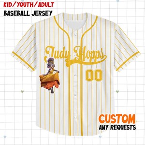 May include: White baseball jersey with yellow pinstripes and accents. Features the name "Judy Hopps" in yellow script, the number "00", and a cartoon character graphic. The jersey has the text "CUSTOM ANY REQUESTS" at the bottom.