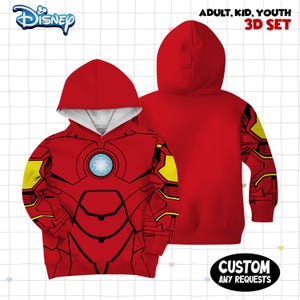 Może przedstawiać: Czerwona bluza z kapturem z grafiką zbroi Iron Mana, ż&oacute;łtymi akcentami i centralnym niebieskim wzorem reaktora łukowego. Tekst głosi Disney, Adult, Kid, Youth 3D Set oraz Custom Any Requests. Bluza posiada długie rękawy oraz kaptur.