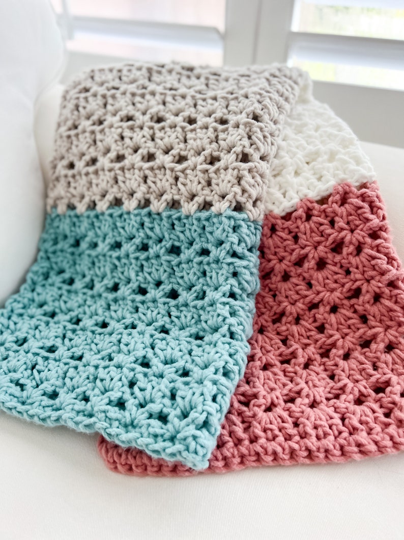 Pu&ograve; includere: Una coperta all'uncinetto con quattro quadrati in diversi colori: beige, bianco, verde acqua e rosa.